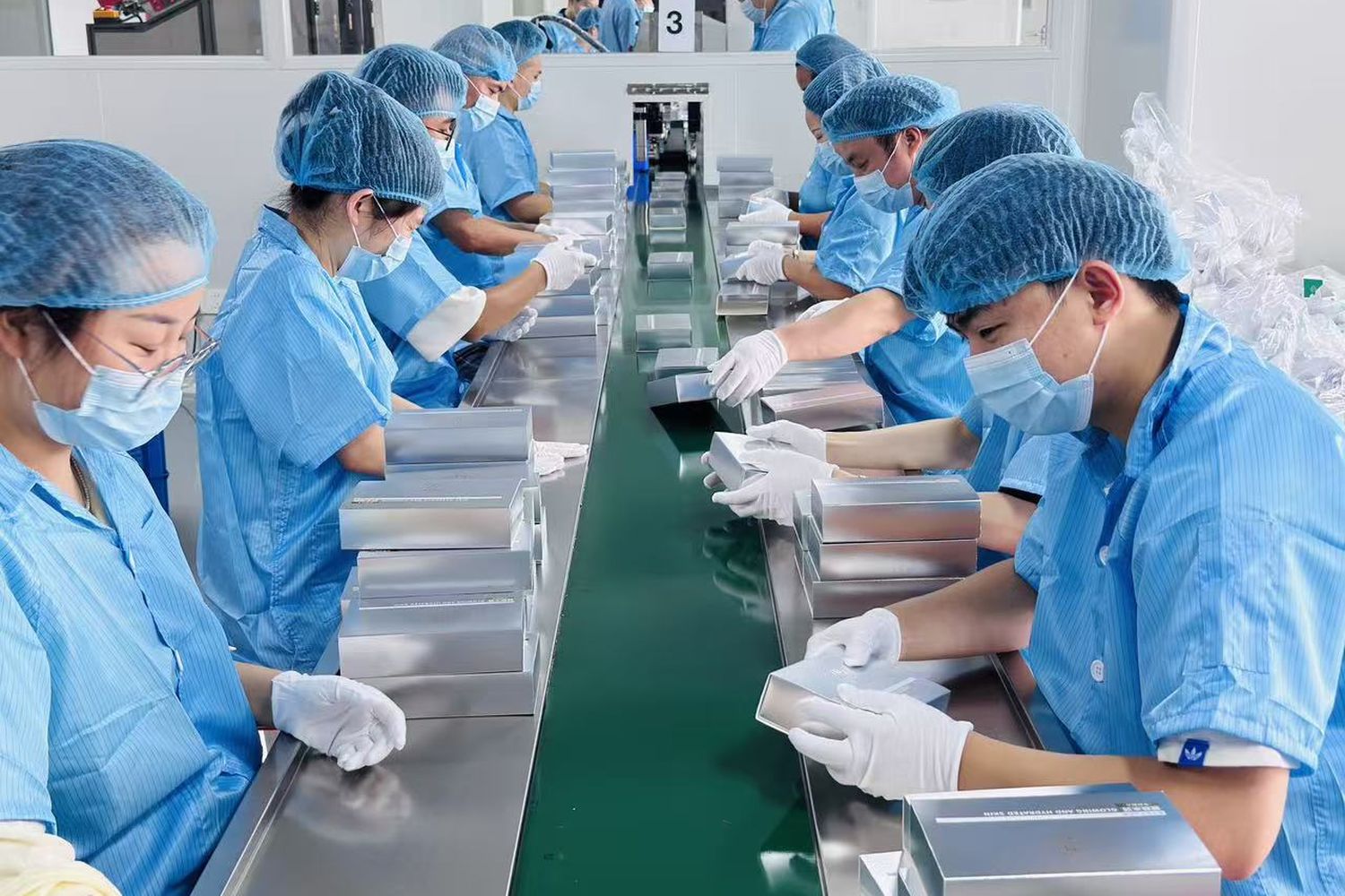 Operators assembling filled skincare units on the cleanroom line at YANE Beauty, Guangzhou
